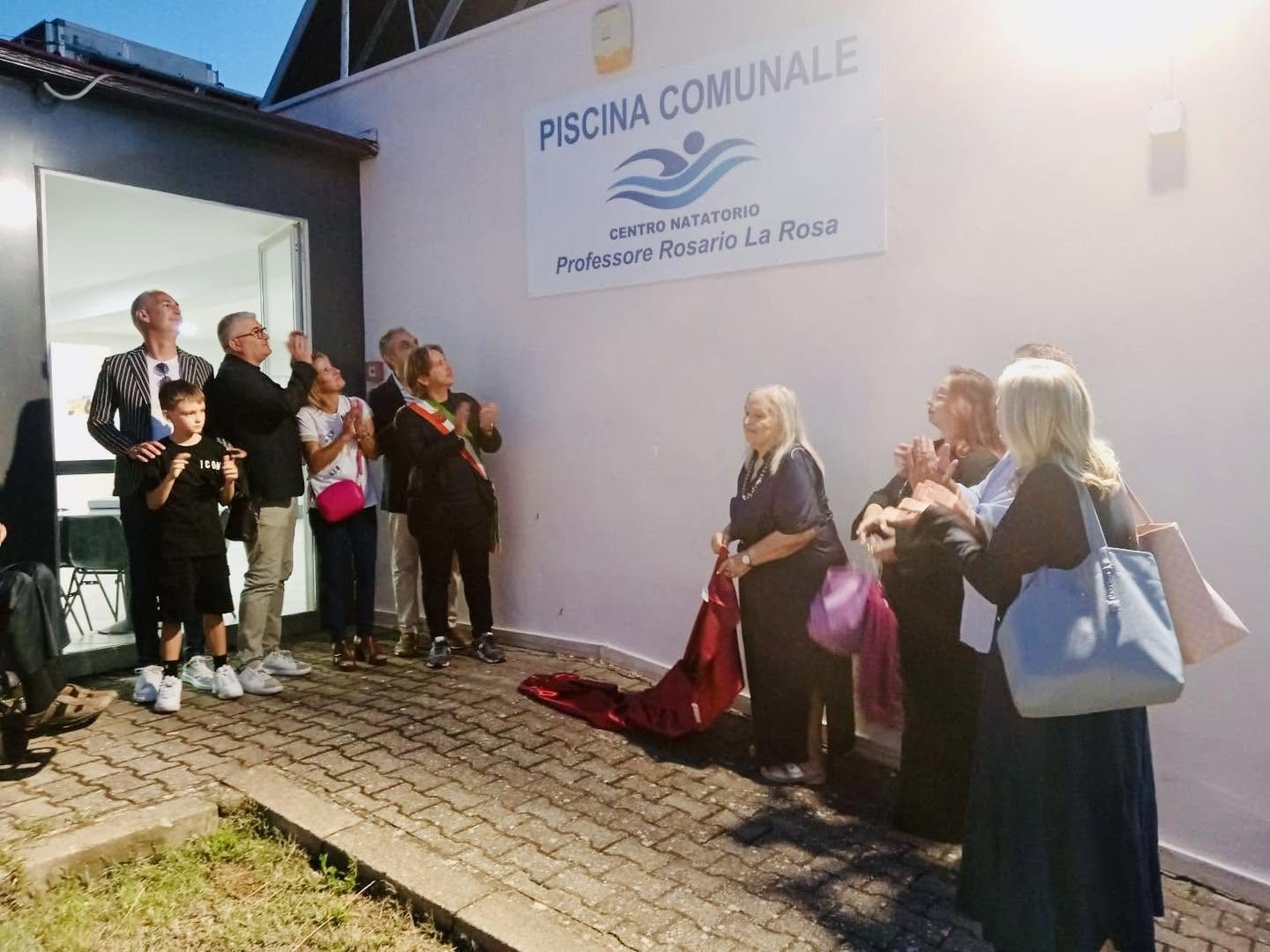 Il momento della scopertura della targa del centro natatorio, con il pubblico che applaude