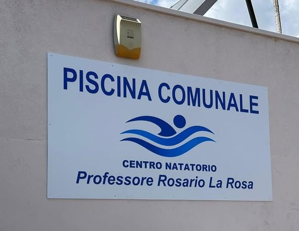 La targa con la scritta Piscina Comunale, Centro Natatorio Professore Rosario La Rosa