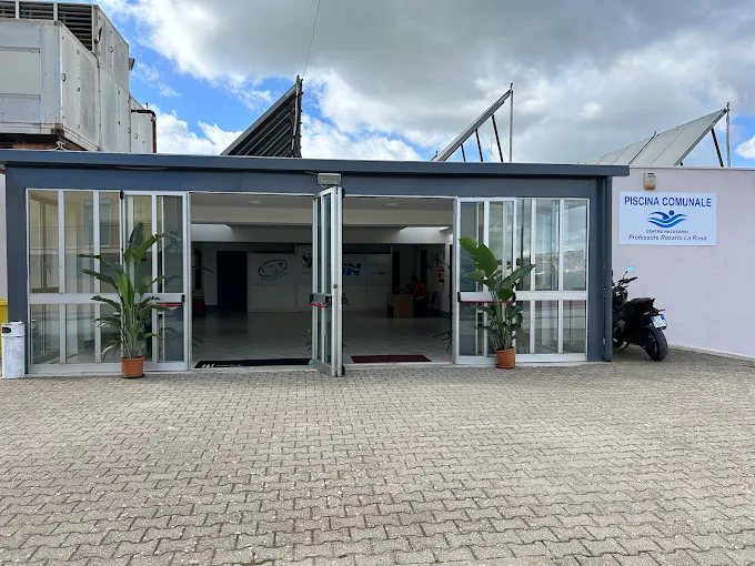 L'ingresso vetrato del centro natatorio con l'insegna della piscina comunale